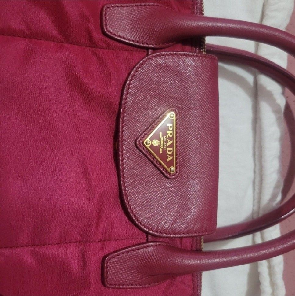 Prada Handbag with Shoulder Strap (Category: Luxury Bags & Wallets) located in Makati City. Submitted by pinkmask (Listing ID 1412151968, Image 1). Description: Preloved ♥️ Authentic Prada Ibisco Tessuto Nylon and Saffiano Leather Tote Bag BN2106. RFS: Decluttering MOP: GCash/ Online banking --BDO or Security Bank (Cash or Cashless Transaction) 💳.