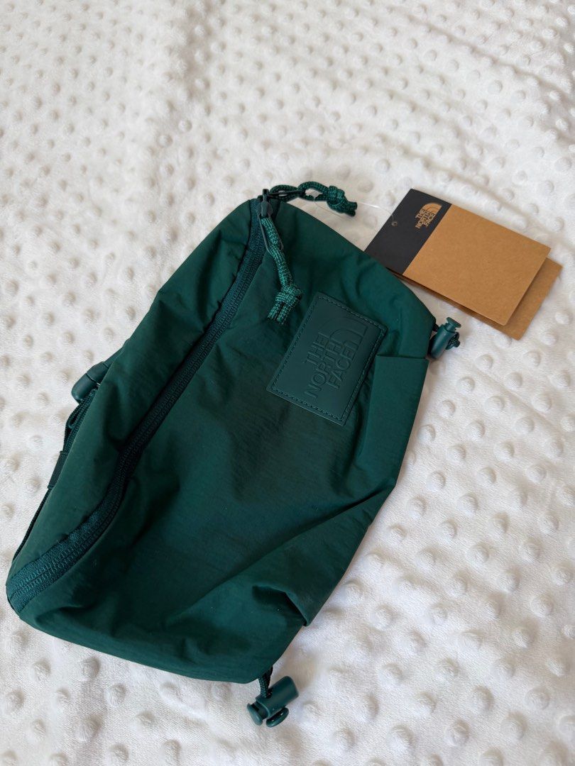 The North Face Waist Bag (Category: Backpacks) located in Malabon City. Submitted by qfayeeeee (Listing ID 1412188456, Image 1). Description: - The North Face waist bag - Color: Dark Green - Main compartment with zipper closure - Adjustable strap - Drawstring closure - The North Face logo patch - Includes original tags - Lined interior.