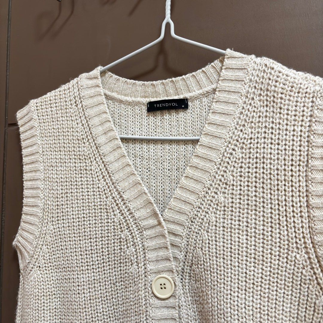 Trendyol Zalora Knit Vest Medium (Category: Sleeveless) located in Balanga. Submitted by heyyletsdeclutter (Listing ID 1412200584, Image 3). Description: - Trendyol knit vest from Zalora - Neutral beige color - V-neck design - Button-down closure - Sleeveless - Ribbed texture - Versatile for layering.