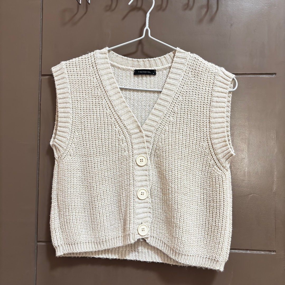 Trendyol Zalora Knit Vest Medium (Category: Sleeveless) located in Balanga. Submitted by heyyletsdeclutter (Listing ID 1412200584, Image 1). Description: - Trendyol knit vest from Zalora - Neutral beige color - V-neck design - Button-down closure - Sleeveless - Ribbed texture - Versatile for layering.