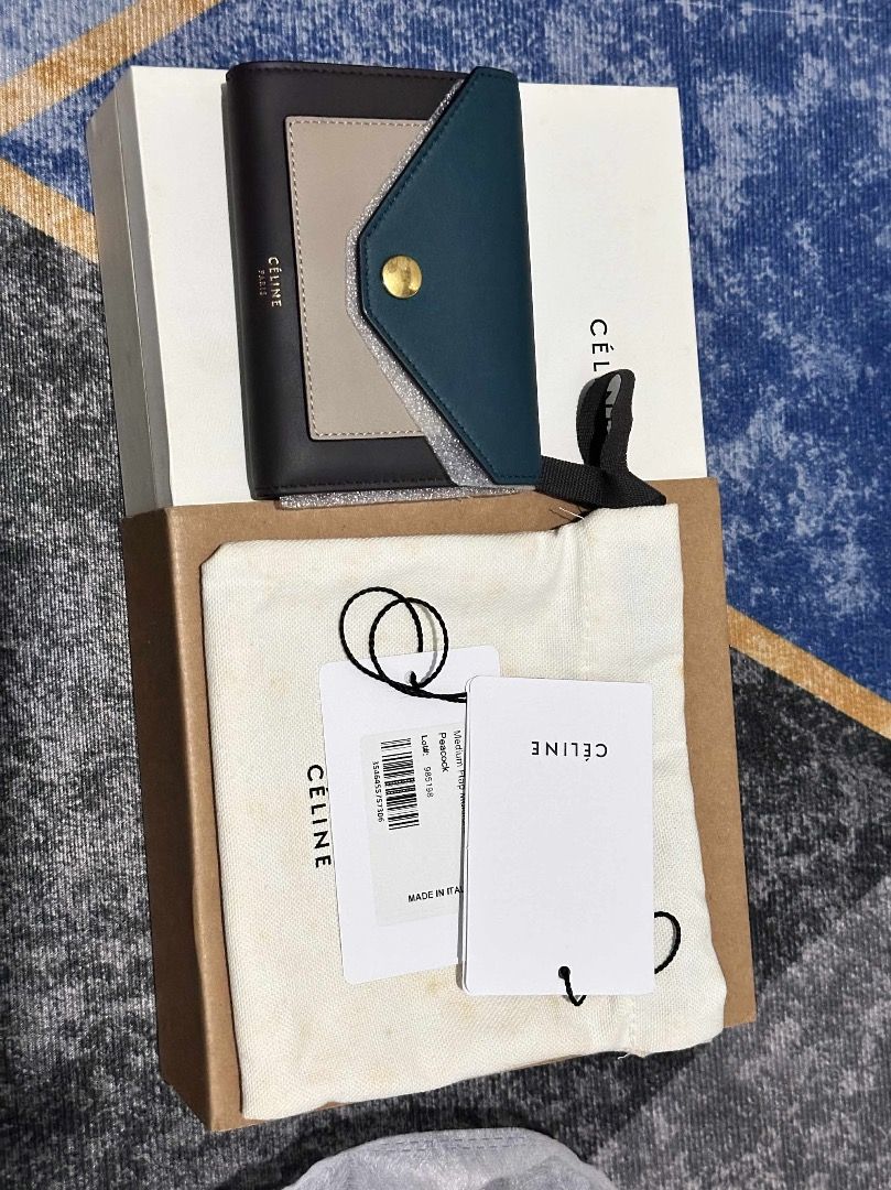 Tri-Fold Wallet Celine unused (Category: Luxury Bags & Wallets) located in Quezon City. Submitted by hellopatchi (Listing ID 1412328942, Image 1). Description: - Authentic Celine Tri-Fold Wallet - Tri-fold design with snap closure - Teal color block flap - Includes original box, dust bag, and tags - Celine logo present.