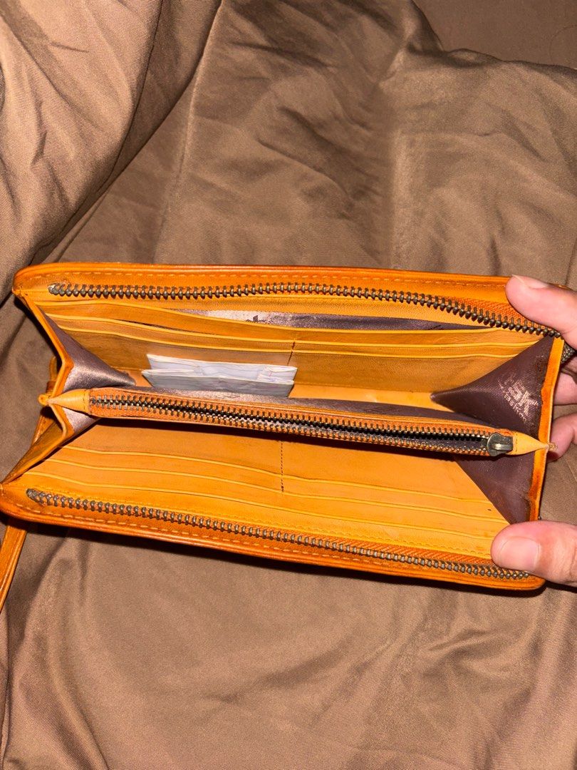 Woven Leather Wallet with Wrist Strap (Category: Wallets & Card holders) located in Pateros City. Submitted by florocampo48421 (Listing ID 1412295211, Image 3). Description: - Woven leather wallet - Warm orange color - Includes wrist strap - Zipper closure - Multiple compartments for cards and cash - Well-maintained, with signs of use.