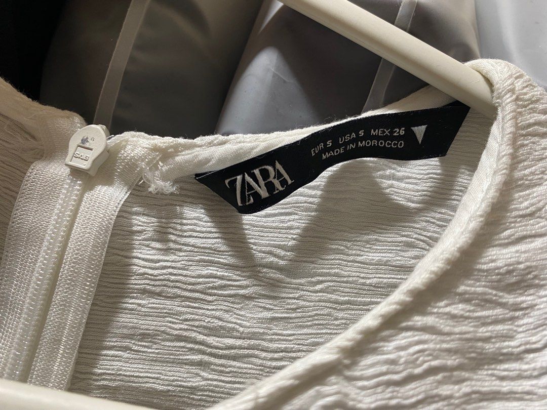 Zara White Off-Shoulder Top (Category: Blouses) located in Pasay City. Submitted by _jkching (Listing ID 1412270499, Image 3). Description: - Zara off-shoulder top - White, textured fabric - Size: S - Features: - Puff sleeves - Gathered front detail - Zipper closure at the back - Made in Morocco.