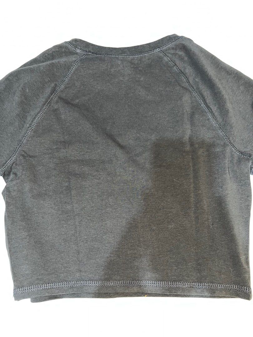 AC/DC High Voltage Rock 'N' Roll Crop Top (Category: Shirts) located in Santa Rita. Submitted by supernicsss (Listing ID 1412408189, Image 2). Description: Crop top features the iconic AC/DC logo with "High Voltage Rock 'N' Roll" and "1976" printed on the front. It has a crew neck and short sleeves. The back of the shirt is plain. The shirt is a dark grey color..