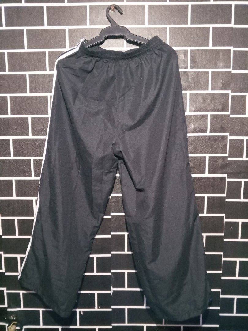 Adidas Black Track Pants with White Stripes (Category: Other Bottoms) located in Las Pinas. Submitted by dydythrift74 (Listing ID 1412426567, Image 2). Description: - Adidas track pants - Black with white stripes - Elastic waistband for comfort - Loose, wide leg design - Made of lightweight material (nylon/polyester blend) - Perfect for casual wear and athletic activities.