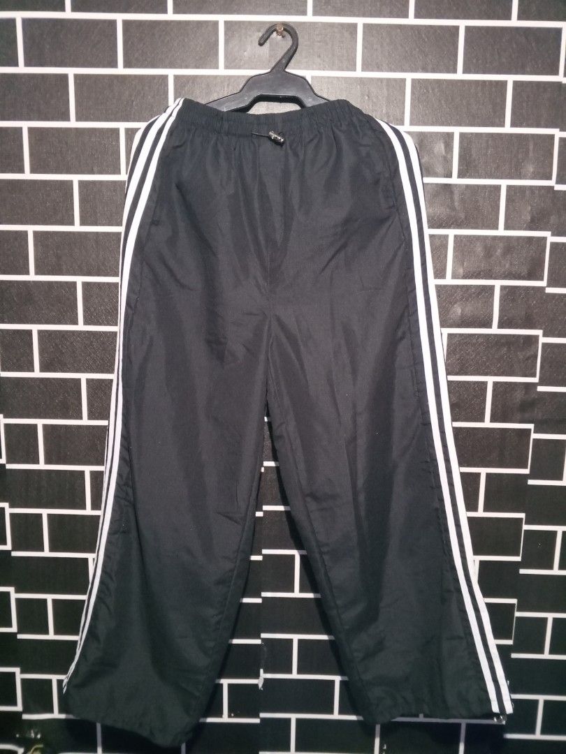 Adidas Black Track Pants with White Stripes (Category: Other Bottoms) located in Las Pinas. Submitted by dydythrift74 (Listing ID 1412426567, Image 1). Description: - Adidas track pants - Black with white stripes - Elastic waistband for comfort - Loose, wide leg design - Made of lightweight material (nylon/polyester blend) - Perfect for casual wear and athletic activities.