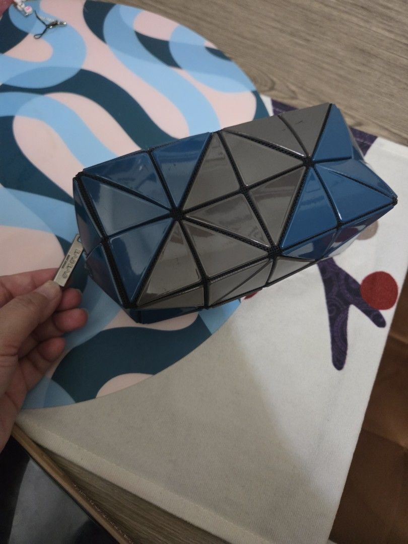Authentic Bao Bao Issey Miyake Clutch (Category: Luxury Bags & Wallets) located in Manila. Submitted by sterling_grace (Listing ID 1412383567, Image 3). Description: - Bao Bao Issey Miyake clutch bag - Unique geometric design - Color: Blue and gray - Triangular shape - Secure zipper closure - Spacious interior - Brand name visible inside - Includes small tag - Perfect for any occasion.