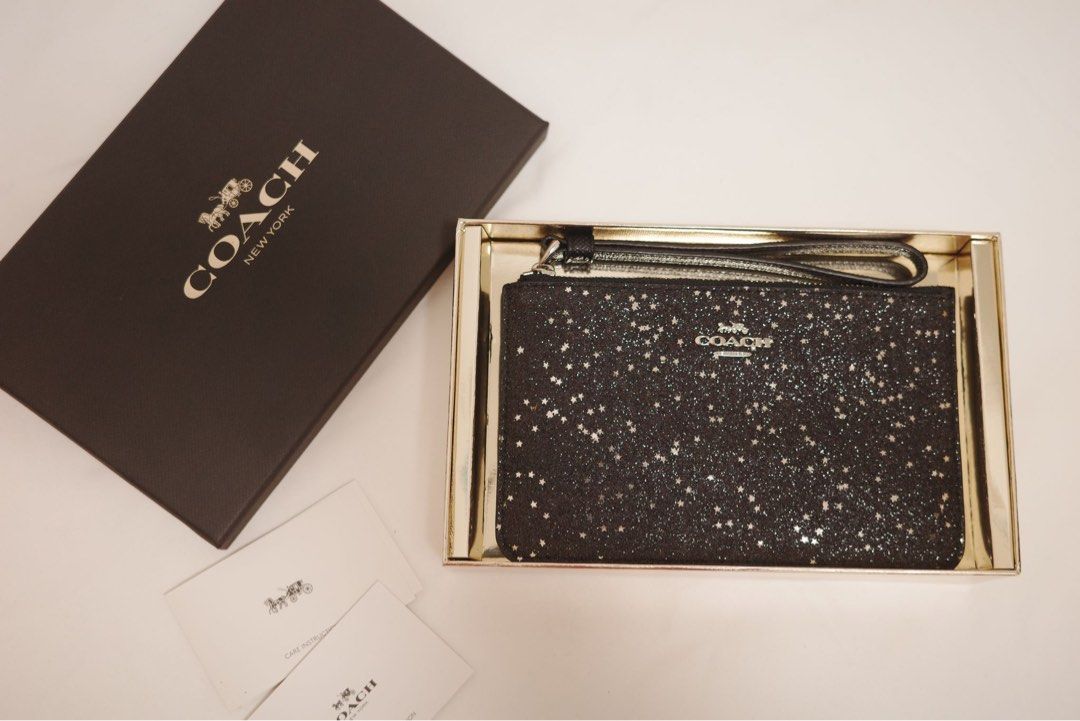 Coach Star Glitter Wristlet (Category: Luxury Bags & Wallets) located in Binangonan. Submitted by pinkesceeluxe (Listing ID 1412482656, Image 2). Description: - Coach wristlet - Black glitter design with star accents - Features wrist strap - Includes Coach logo - Comes with original box and care cards - New and unused condition.