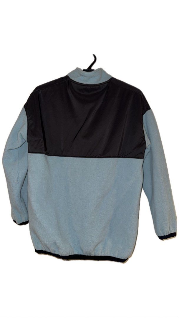 Colorblock Fleece Pullover Jacket (Category: Activewear) located in Binan City. Submitted by incairo (Listing ID 1412351449, Image 2). Description: - Colorblock design: Black upper panel, light blue lower panel. - Quarter-zip closure. - Features a small logo on the chest. - Elastic cuffs for a snug fit. - Drawstring hem for adjustable comfort. - Made from fleece material. - Comfortable and stylish outerwear..