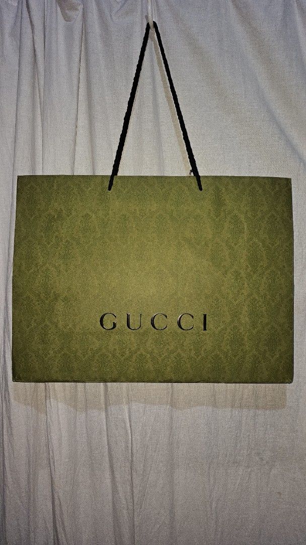 Gucci Paper Bag (Category: Luxury Bags & Wallets) located in San Jose del Monte. Submitted by stellarbeauty (Listing ID 1412424309, Image 1). Description: - Authentic Gucci paper bag - Features the Gucci logo - Black handles - Green color - Perfect for gifting or collecting.