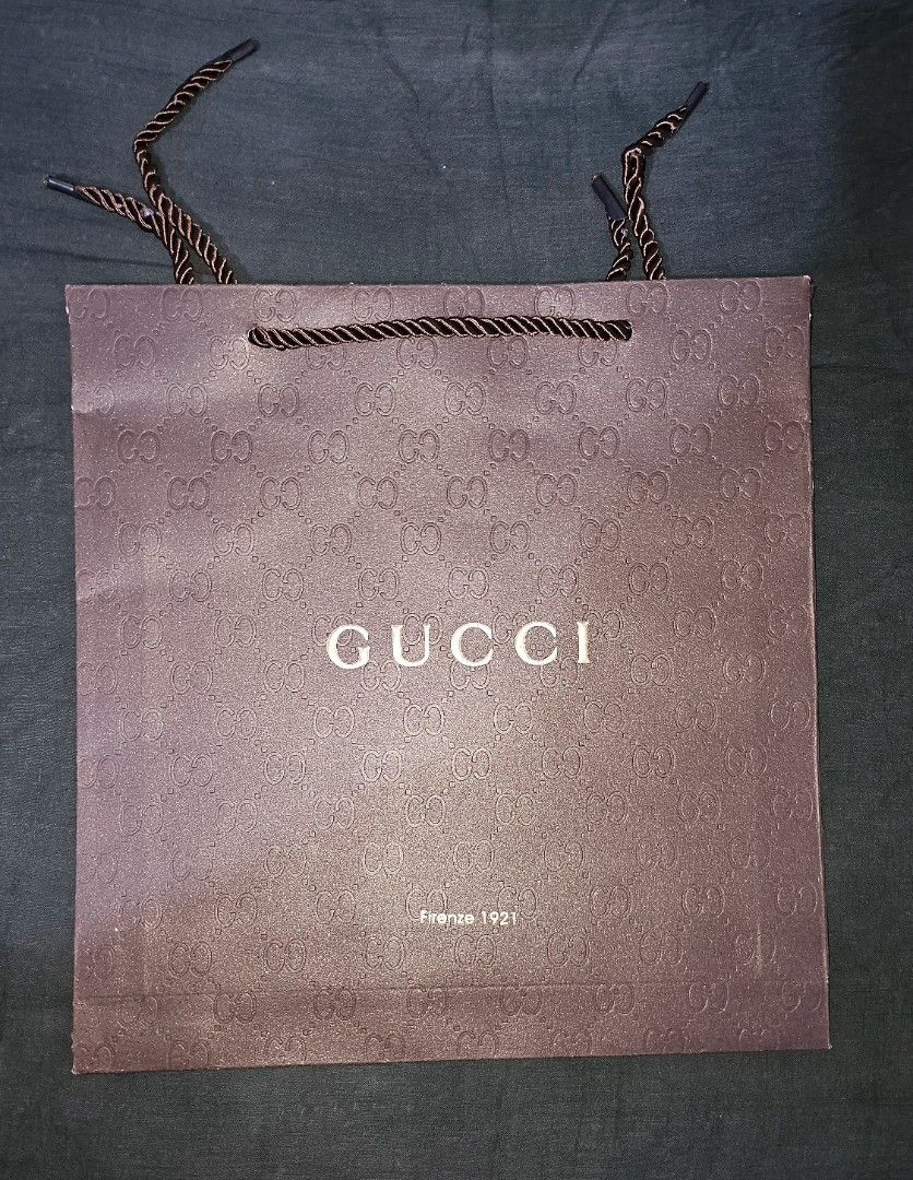 Gucci Paper Bag (Category: Luxury Bags & Wallets) located in San Jose del Monte. Submitted by stellarbeauty (Listing ID 1412450881, Image 1). Description: Authentic Gucci paper bag. Features the Gucci logo on the front. Includes rope handles. The bag is brown in color. Perfect for gifting or collecting..