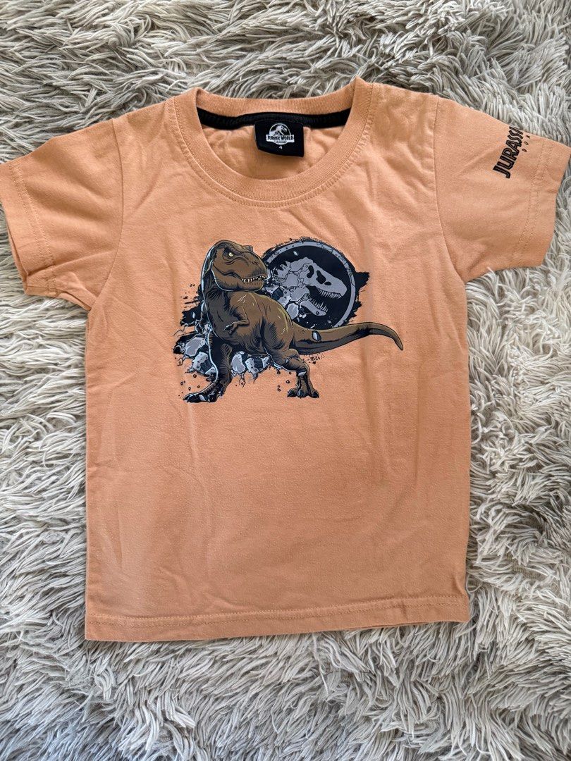 Jurassic World T-shirt (Category: Tshirts & Polo Shirts ) located in Muntinlupa City. Submitted by caistuff (Listing ID 1412390221, Image 1). Description: LAST PRICE POSTED ALREADY. - Jurassic World t-shirt for kids - Features a dinosaur graphic on the front - Jurassic World logo on the sleeve - Short-sleeved - Round neckline - Light brown color Dimes: - Length: 17 in - Width: 12 in.