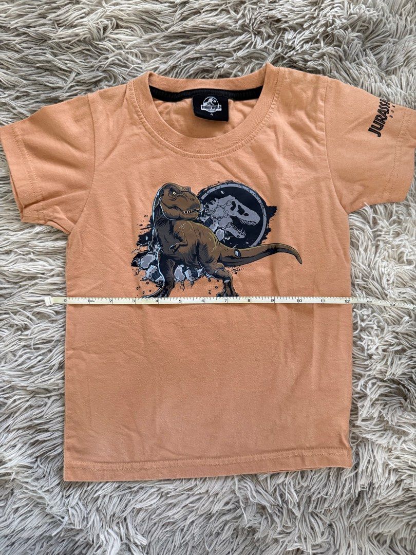 Jurassic World T-shirt (Category: Tshirts & Polo Shirts ) located in Muntinlupa City. Submitted by caistuff (Listing ID 1412390221, Image 3). Description: LAST PRICE POSTED ALREADY. - Jurassic World t-shirt for kids - Features a dinosaur graphic on the front - Jurassic World logo on the sleeve - Short-sleeved - Round neckline - Light brown color Dimes: - Length: 17 in - Width: 12 in.