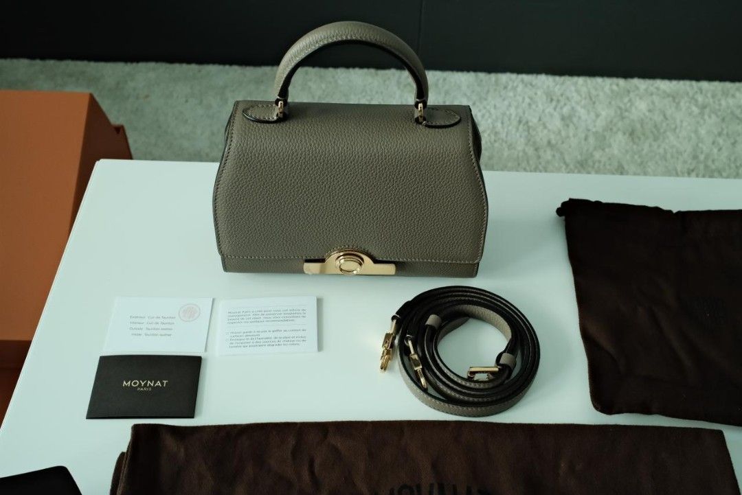 Moynat Rejane Handbag Black (Category: Luxury Bags & Wallets) located in Makati City. Submitted by roguetrader12 (Listing ID 1412458175, Image 2). Description: Measures: 20cm L x 15cm H x 8cm W (approx) Comes with a detachable strap, dust bag, shopping bag, and box Material: Taurillon Leather Hardware: Gold Hardware Purchase History: Bought in Paris, France Made in France Complete Authenticity Card and Care Cards Retail Price: €4,000 PHP 225,000 