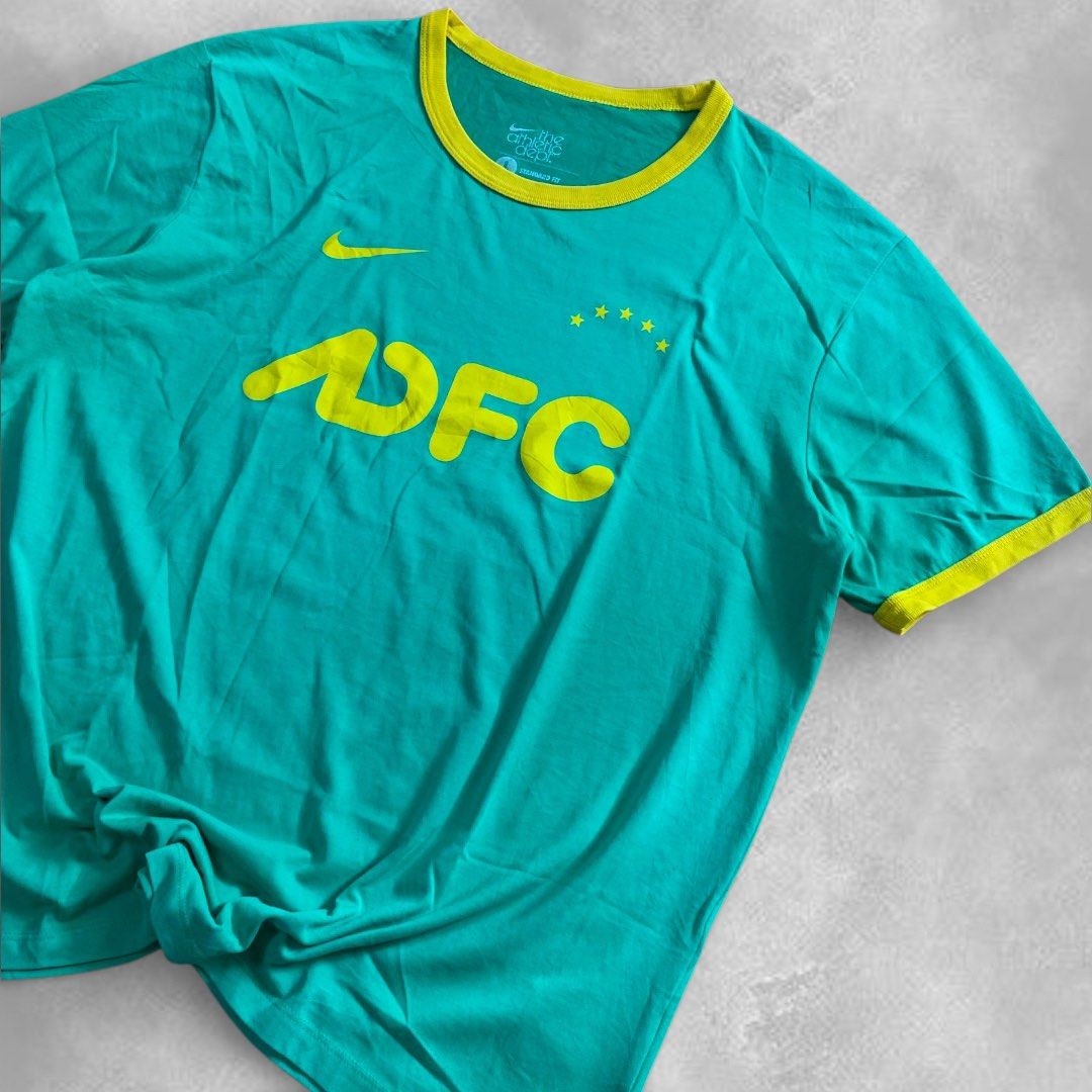 Nike Athletic Dept. DFC T-shirt (Category: Tshirts & Polo Shirts ) located in Cebu City. Submitted by peakstuffs (Listing ID 1412370881, Image 3). Description: - Nike Athletic Dept. t-shirt - Teal body with yellow collar and sleeve accents - Features "DFC" logo on the front - Includes Nike logo and stars - Authentic Nike product (see tag for product code).