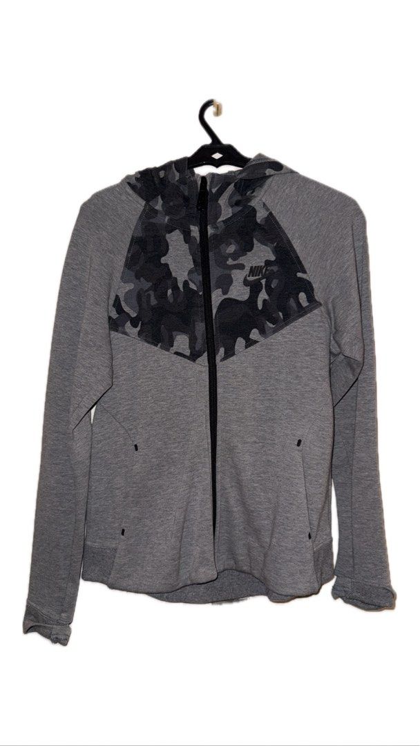 Nike Camo Panel Zip Hoodie (Category: Activewear) located in Binan City. Submitted by incairo (Listing ID 1412351450, Image 1). Description: - Gray Nike hoodie - Camo panel on chest and hood - Full-length zipper - Two side pockets - Nike logo on chest - Ribbed hem and cuffs - Solid gray back with camo panel.
