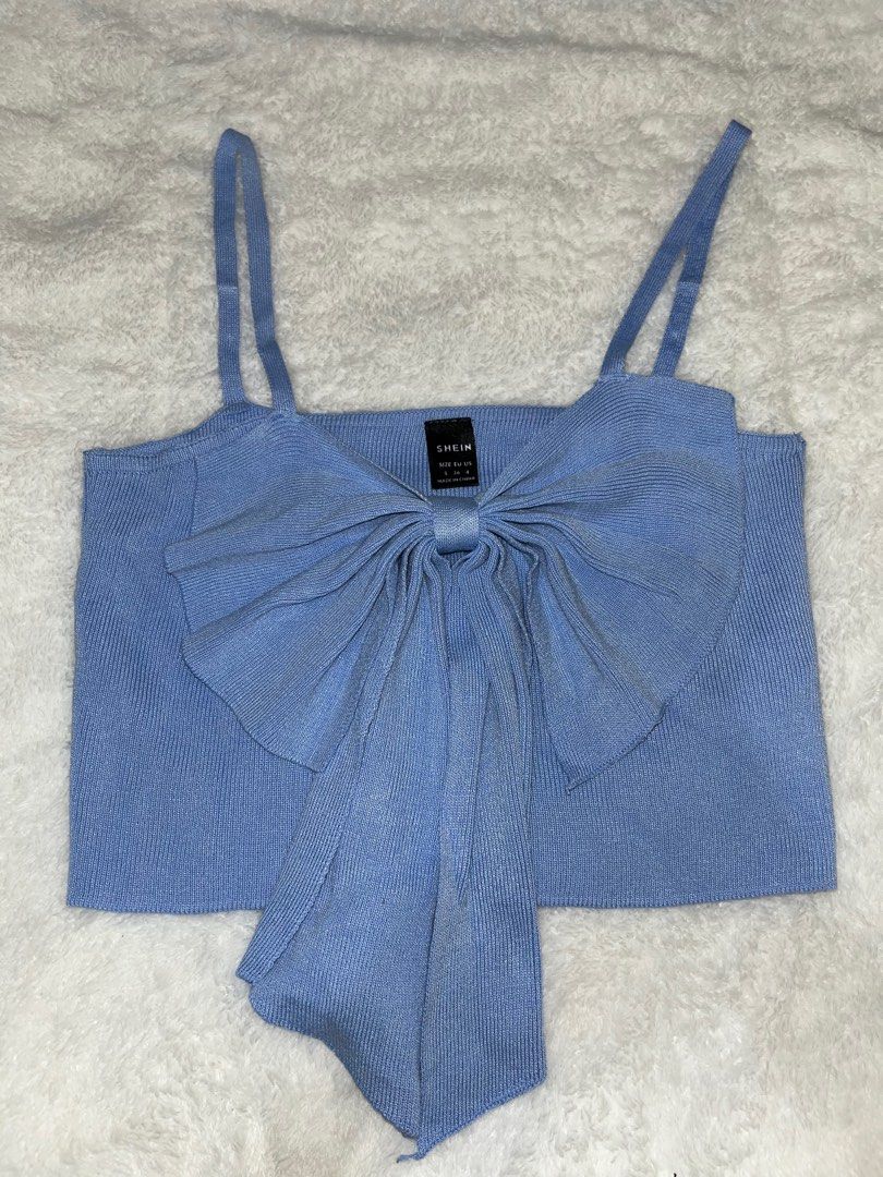 Shein Bow Detail Crop Top (Category: Sleeveless) located in Santa Rita. Submitted by supernicsss (Listing ID 1412407195, Image 1). Description: - Shein crop top - Unique bow detail - Adjustable straps - Ribbed knit texture - Light blue color - Straight neckline at the back - Perfect for various occasions.