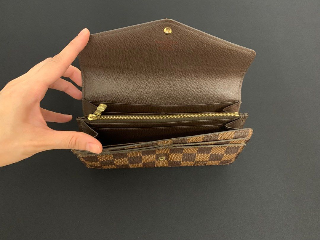 Authentic Louis Vuitton Sarah Wallet – Damier Ebene Canvas (Category: Luxury Bags & Wallets) located in Paranaque City. Submitted by curatedthrifty (Listing ID 1407705540, Image 2). Description: 📌 Condition: Good – clean inside & out, with gentle signs of use 📌 Features LV’s classic Damier Ebene coated canvas with a spacious, functional interior 📌 Timeless continental wallet design that fits cards, bills, and coins with ease.