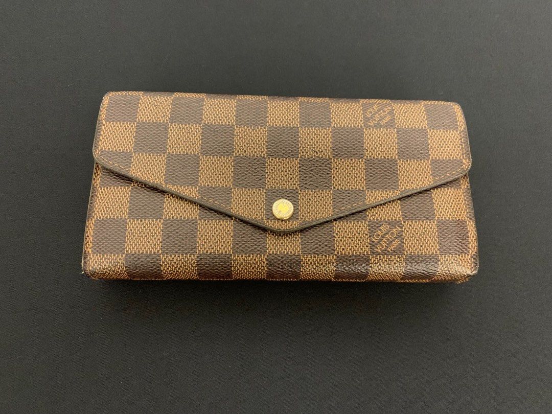 Authentic Louis Vuitton Sarah Wallet – Damier Ebene Canvas (Category: Luxury Bags & Wallets) located in Paranaque City. Submitted by curatedthrifty (Listing ID 1407705540, Image 1). Description: 📌 Condition: Good – clean inside & out, with gentle signs of use 📌 Features LV’s classic Damier Ebene coated canvas with a spacious, functional interior 📌 Timeless continental wallet design that fits cards, bills, and coins with ease.