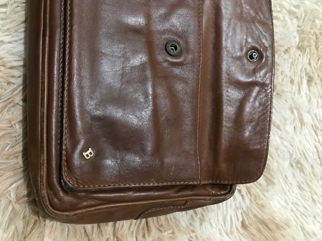 Bally Leather Clutch (Category: Luxury Bags & Wallets) located in Gamu. Submitted by 2022bagsbunny (Listing ID 1407739505, Image 2). Description: - Vintage brown leather clutch - Top zipper closure - Front flap pocket - Wrist strap - Small logo detail - Lined interior.