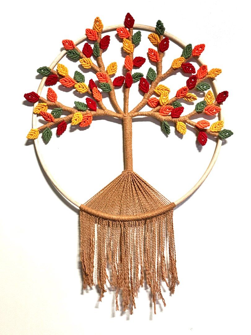 Macrame Tree of Life Wall Hanging (Category: Wall Decor) located in Pasig City. Submitted by sinta_studio (Listing ID 1407644697, Image 1). Description: For PRE-ORDER Handmade macrame wall hanging featuring a tree of life design. The tree has colorful leaves in shades of red, orange, yellow, and green. It is attached to a wooden hoop and has a fringe at the bottom. Perfect for adding a touch of nature and artistry to your home decor..