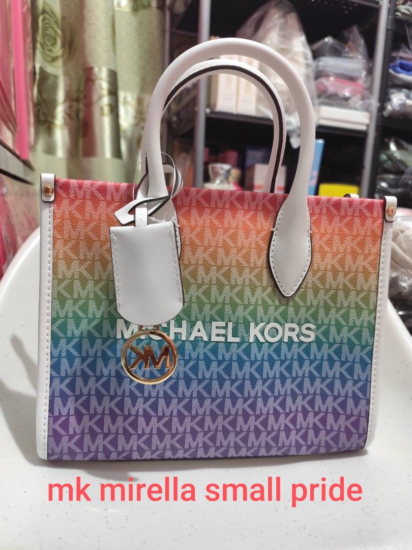 Michael Kors Mirella Small Pride Handbag (Category: Luxury Bags & Wallets) located in Imus. Submitted by jmakati22717201 (Listing ID 1407622923, Image 2). Description: - Michael Kors Mirella Small Pride handbag - Vibrant rainbow pattern - Top handle and detachable shoulder strap - Includes a white tag with brand and model - Interior lined with pink fabric - Gold-tone logo charm.