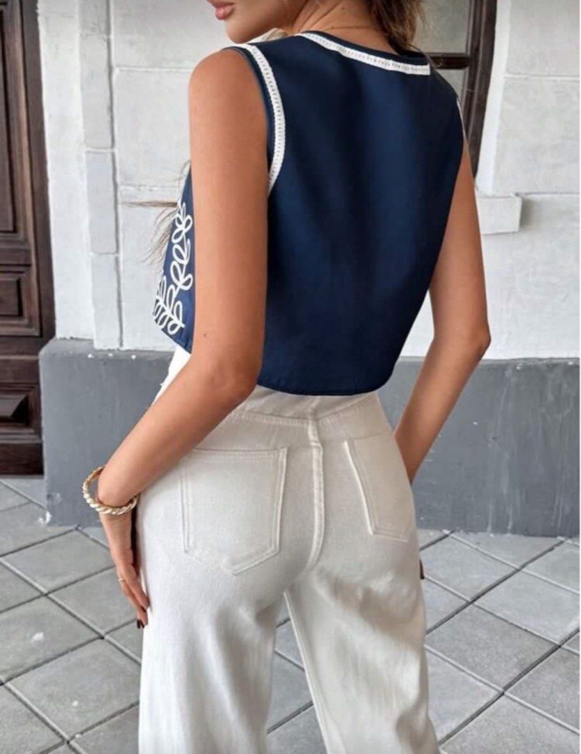 Navy Blue Floral Embroidered Vest Top (Category: Sleeveless) located in San Juan City. Submitted by kassyjsn (Listing ID 1407714191, Image 2). Description: Classy top! Size S but fits M also. Used only for 2 hours :) Shoulder: 14in Length: 15in Bust: 37in - Navy blue vest - White floral embroidery - V-neck design - Button-down closure - White lining and trim - Great for layering - Chic and stylish.