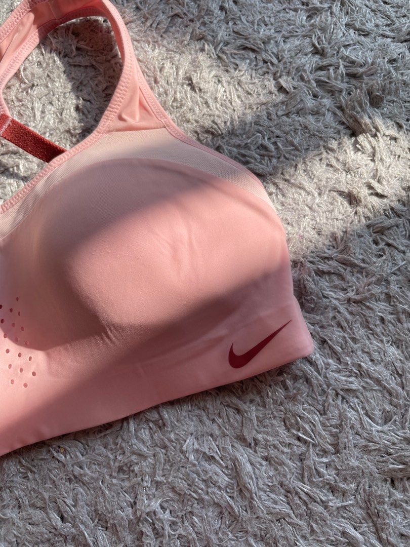 Nike Sports Bra (Category: Activewear) located in Mandaluyong City. Submitted by mclldmrl (Listing ID 1407727525, Image 3). Description: - Nike sports bra - Light pink color - Adjustable straps - Hook-and-eye closure - Mesh panel - Nike logo on front - Made in China - Suitable for high-impact activities.