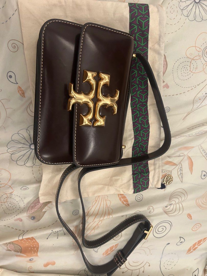 Tory Burch Brown Leather Crossbody Bag (Category: Luxury Bags & Wallets) located in Cavite. Submitted by baglover26 (Listing ID 1407642576, Image 1). Description: - Tory Burch crossbody bag - Rich brownish red leather - Gold-tone logo and buckle - Includes dust bag - Structured design with white stitching - Adjustable long strap for shoulder or crossbody wear.