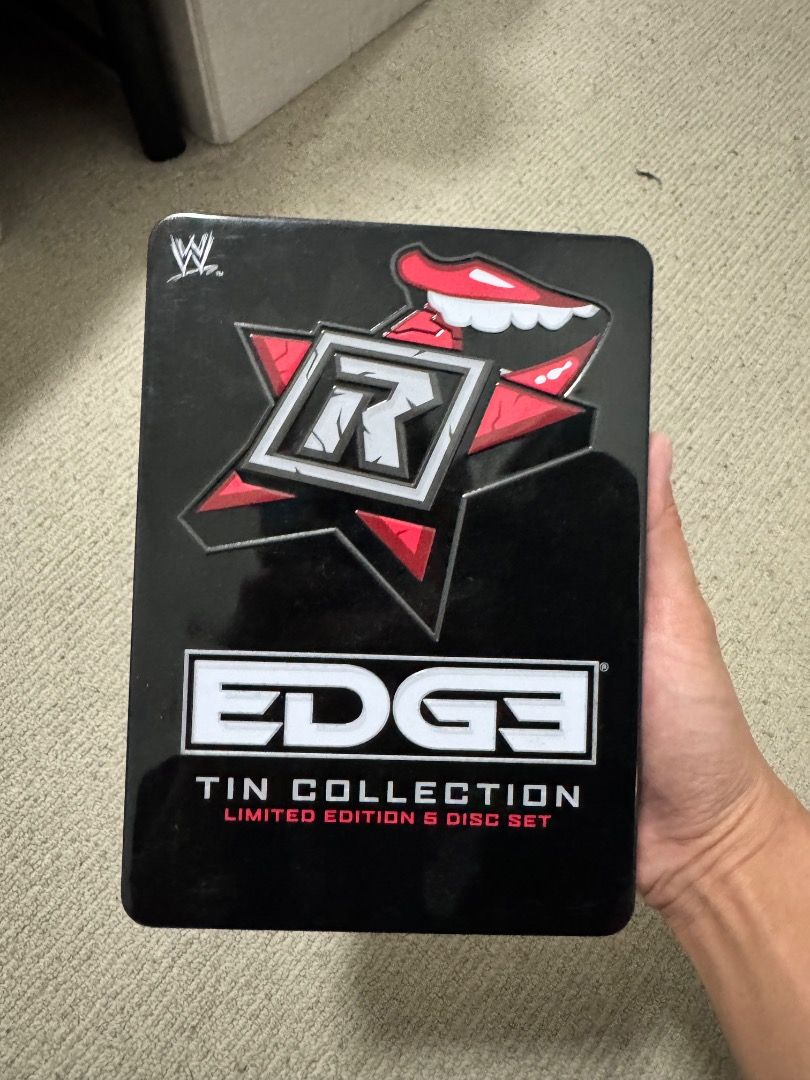 WWE Edge Tin Collection 5 Disc Set (Category: CDs & DVDs) located in Quezon City. Submitted by thegame01 (Listing ID 1407676147, Image 1). Description: WWE Edge Tin Collection 5 Disc Set. It includes Judgment Day 2009, Edge: Decade of Decadence, and Royal Rumble 2010. The set is a limited edition. The tin features the Edge logo with a red star and the word "EDGE" in bold white letters. The back of the tin shows the included DVDs. Item is with me 