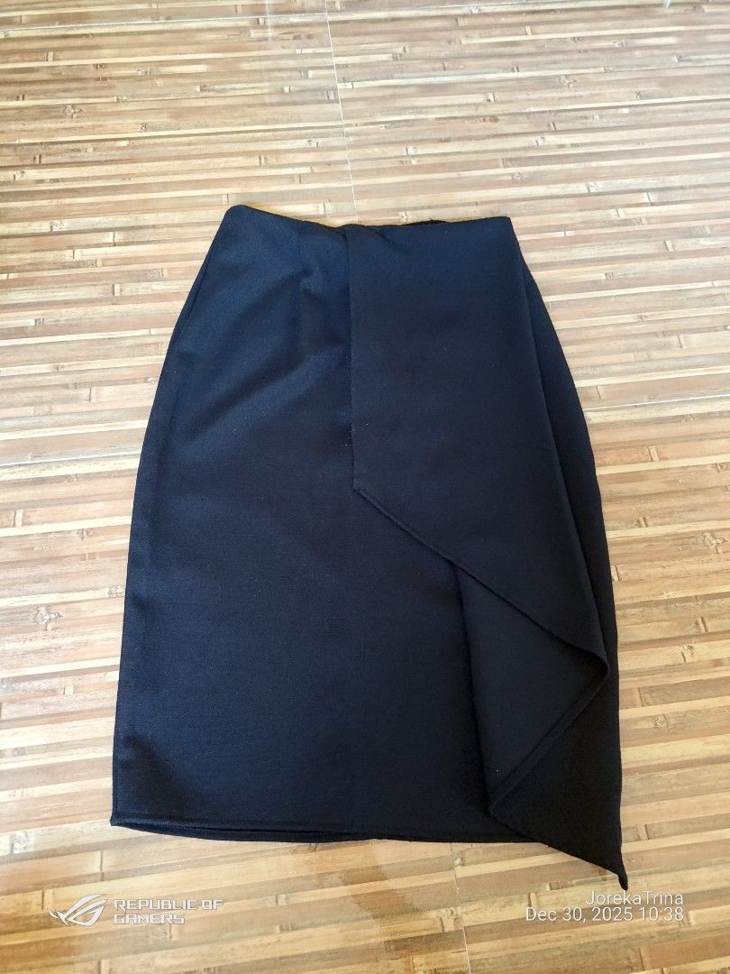 Black overlap skirt (Category: Skirts) located in San Fernando. Submitted by masterambrose13 (Listing ID 1412540488, Image 1). Description: skirt pictured is a black overlap mini skirt (also referred to as a wrap or faux-wrap skirt). This style is characterized by a panel of fabric that crosses over the front of the skirt, creating an asymmetrical hemline..