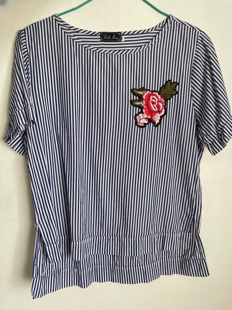 Blue Striped Top with Floral Applique (Category: Blouses) located in Manila. Submitted by jamieeelq (Listing ID 1412561027, Image 1). Description: - Bella Moda medium top - Blue and white striped design - Floral applique detail - Round neckline - Short sleeves - Layered hem with side slits.