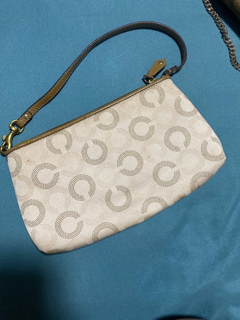 Coach Signature Clutch (Category: Luxury Bags & Wallets) located in Quezon City. Submitted by Daichy (Listing ID 1412568846, Image 2). Description: - Coach signature clutch - Includes wrist strap - Light-colored fabric with repeating circle pattern - Dark brown trim and strap - Coach logo on front - Gold-colored clasp and hardware.