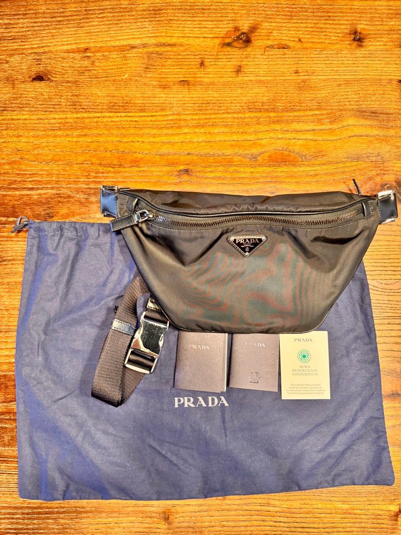 Prada Re-Nylon Waist Bag (Category: Luxury Bags & Wallets) located in Taguig. Submitted by pritsu (Listing ID 1412548901, Image 2). Description: Decluttering personal items. Bought in Amsterdam. PM for more photos. - Authentic Prada Re-Nylon waist bag - Black nylon exterior - Features Prada logo plaque - Adjustable strap - Zip closure - Includes dust bag - Comes with authenticity cards - Blockchain certificate included.