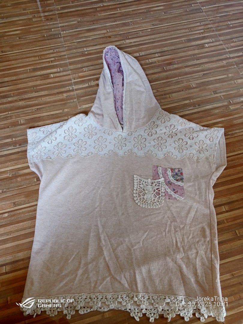 pullover-style hoodie (Category: Shirts) located in San Fernando. Submitted by masterambrose13 (Listing ID 1412539718, Image 1). Description: short-sleeve, light pink hoodie featuring extensive white lace trim and a unique, striped patchwork front pocket. The style is casual and incorporates delicate, detailed accents..