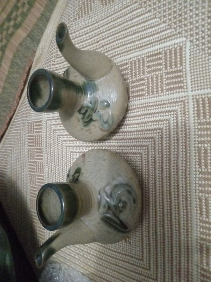 Vintage Japanese Sake Pourers (Category: Dinnerware & Cutlery) located in Manila. Submitted by padillahe35291 (Listing ID 1412621607, Image 2). Description: Set of two vintage Japanese sake pourers. They have a unique design with a spout and a wide opening. The pourers feature a decorative floral design. The color is a mix of beige and green. These pourers are perfect for serving sake in style..