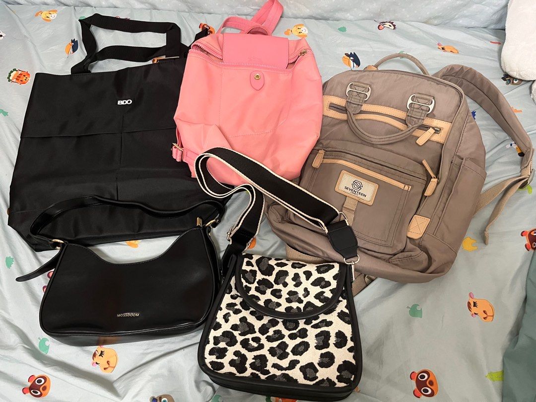 Assorted Bags for take all (Category: Tote Bags) located in Angeles City. Submitted by pheeebees (Listing ID 1412763974, Image 1). Description: 5 assorted bags for take all 1. BDO tote bag - new; no flaws 2. pink backpack - longchamp; not original; has signs of usage 3. Seventeen backpack - original; has signs of usage 4. black handbag - mosedoom from tiktok shop; lightly used 5. cow print shoulder bag - bought in sm; used for a few times only.