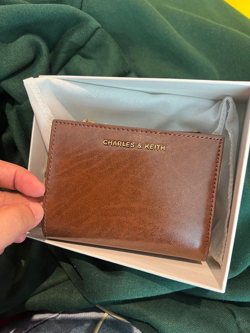 Charles & Keith Brown Wallet (Category: Everything Else Others) located in Kawit. Submitted by richconcept (Listing ID 1412779068, Image 1). Description: - Multiple card slots - Includes original packaging and tags - Compact and functional design - Ideal for everyday use Complete set: paper bag, dust bag and box included .