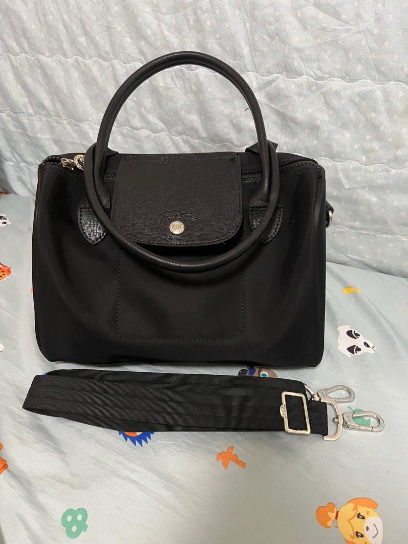 Longchamp Handbag / Doctors Bag (Category: Luxury Bags & Wallets) located in Angeles City. Submitted by pheeebees (Listing ID 1412760390, Image 1). Description: Black Longchamp Le Pliage Cuir handbag with a detachable shoulder strap. Features a top handle and a flap closure. The bag has a zipper closure and silver-tone hardware. Made in France. The bag shows some signs of wear, including some white spots on the exterior. - has white spots due to 
