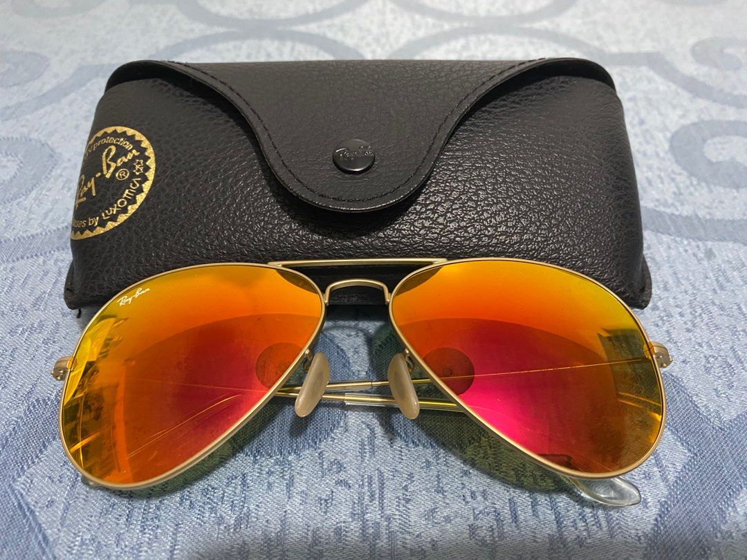 Ray-Ban Aviator Sunglasses (Category: Sunglasses & Eyewear) located in Cagayan de Oro. Submitted by cu_2022 (Listing ID 1412856092, Image 1). Description: - Authentic Ray-Ban Aviator sunglasses - Gold frame with orange-tinted lenses - Includes original black leather case - Ray-Ban logo visible on lens and case - Classic aviator design - Case features a snap closure.