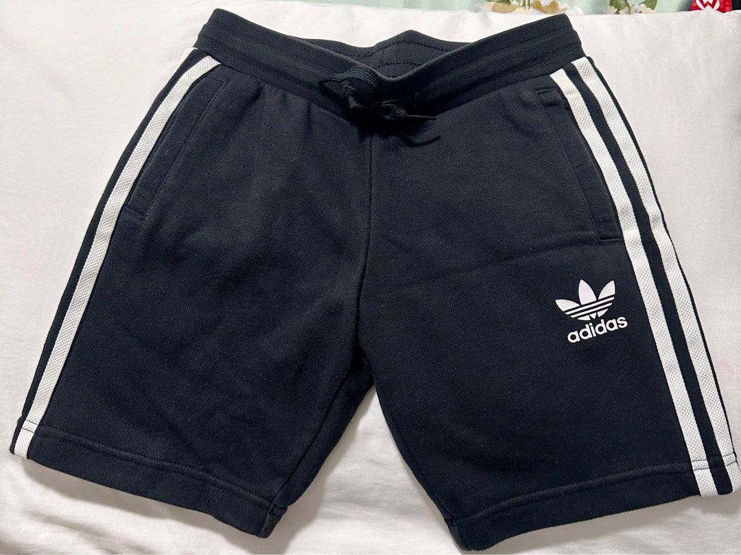 Adidas Kids Shorts (Category: Babies & Kids Fashion) located in Las Pinas. Submitted by tomarigato (Listing ID 1407760687, Image 2). Description: - Adidas kids shorts - Color: Black with white stripes - Adidas logo on front - Drawstring waistband - Size: 130 (fits 7-8 years old) RFS: Outgrown take note: photo 3 - small hole at the back below left side.