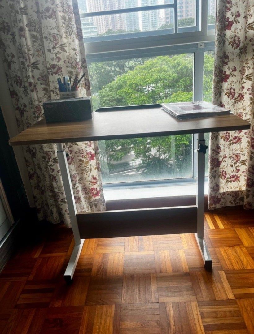 Adjustable foldable table (Category: Tables & Sets) located in Singapore. Submitted by simplicity0117 (Listing ID 1407889294, Image 1). Description: the table max height is 80cm. Features a wood-grain tabletop and a sturdy white frame. The table is perfect for studying or working from home. It has a small lip to prevent items from sliding off. Desk size 80*50 cm. The height is adjustable to suit your needs. the width is around 80cm.