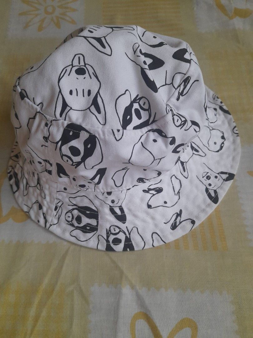 Bucket Hat - Artwork Dog Print (Category: Looking For) located in San Pedro. Submitted by JohnsonKeeps (Listing ID 1407827285, Image 2). Description: Bucket hat features a playful dog print. It has a white exterior with black dog illustrations and a peach-colored interior lining. The hat includes a tag from the brand "Artwork"..