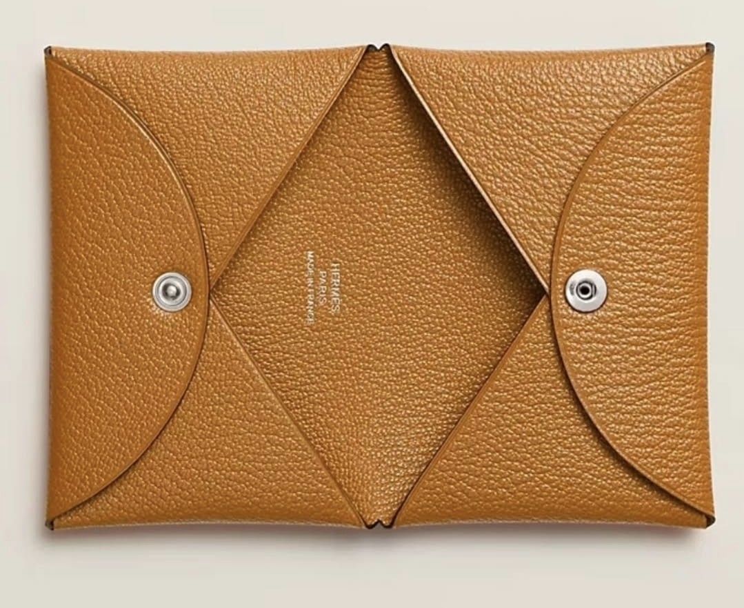 Hermès Card Holder (Category: Luxury Bags & Wallets) located in Batangas. Submitted by damirez88 (Listing ID 1407901605, Image 2). Description: - Authentic Hermès card holder - Unique envelope design with snap closure - Available colors: Black and Tan - Features Hermès logo and "Made in France" stamp - Perfect for cards and small essentials.