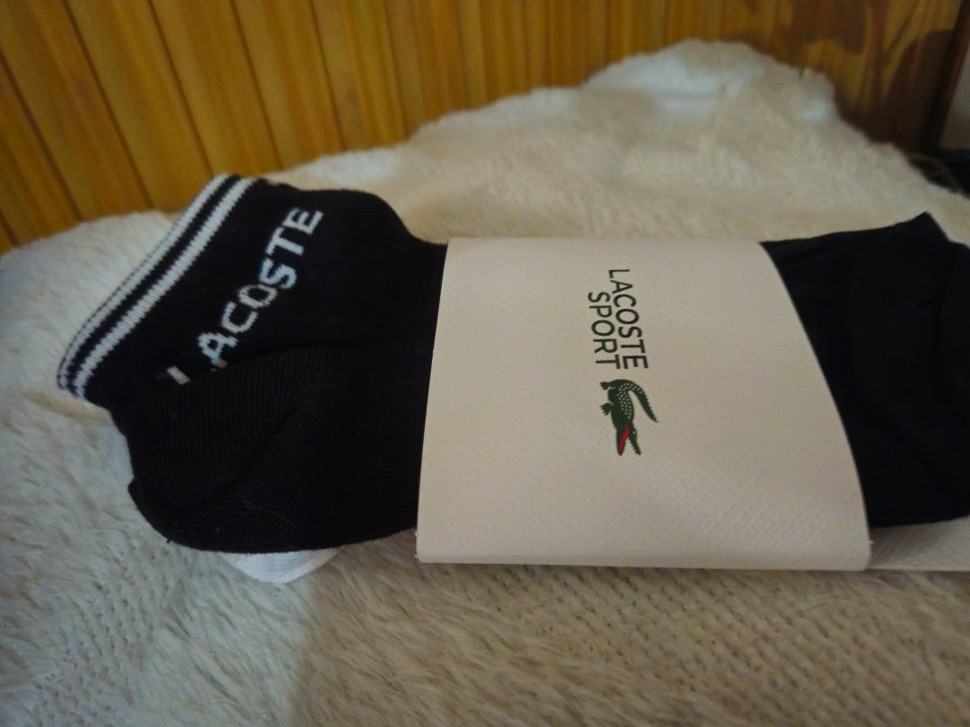 Lacoste Sport Socks (Category: Socks) located in Manila. Submitted by tampipi (Listing ID 1407916081, Image 1). Description: Pair of black Lacoste Sport socks. Features the Lacoste logo on the packaging. The socks have the Lacoste logo on the cuff. The socks are black with white stripes on the cuff..