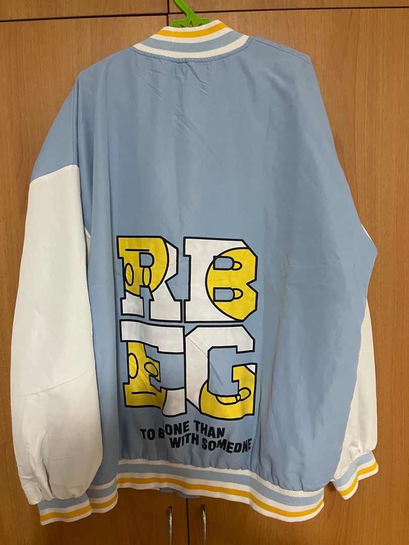 Varsity Jacket with Letter R and Graphic Print (Category: Coats, Jackets and Outerwear) located in Manila. Submitted by lucas_cl (Listing ID 1407810499, Image 2). Description: - Light blue varsity jacket - White sleeves - Large "R" graphic on front - Graphic print on back - Black interior lining - Button-up closure - Yellow and blue striped collar and cuffs - Relaxed fit NO ISSUE, LIKE NEW.