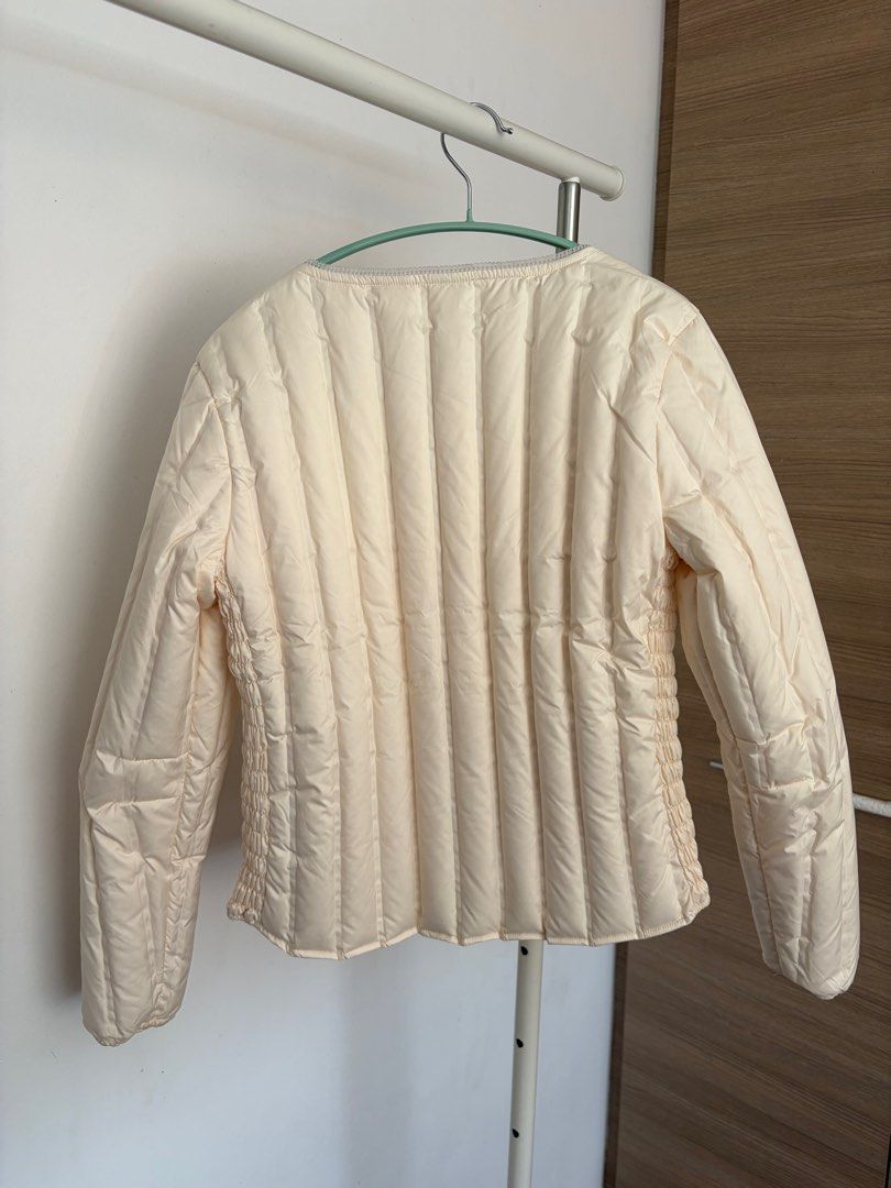 Compact down jacket (Category: Coats, Jackets and Outerwear) located in Singapore. Submitted by n_nzz (Listing ID 1407982925, Image 2). Description: - light ceam-colored compact down jacket with 68g of down feather - Zip-up front - Two pockets - never worn before but removed tag - suitable for UK size 8/10 after adding inner layer/ sweater - shoulder width 40cm, chest 92-102cm ( elastic) - Ideal for layering.