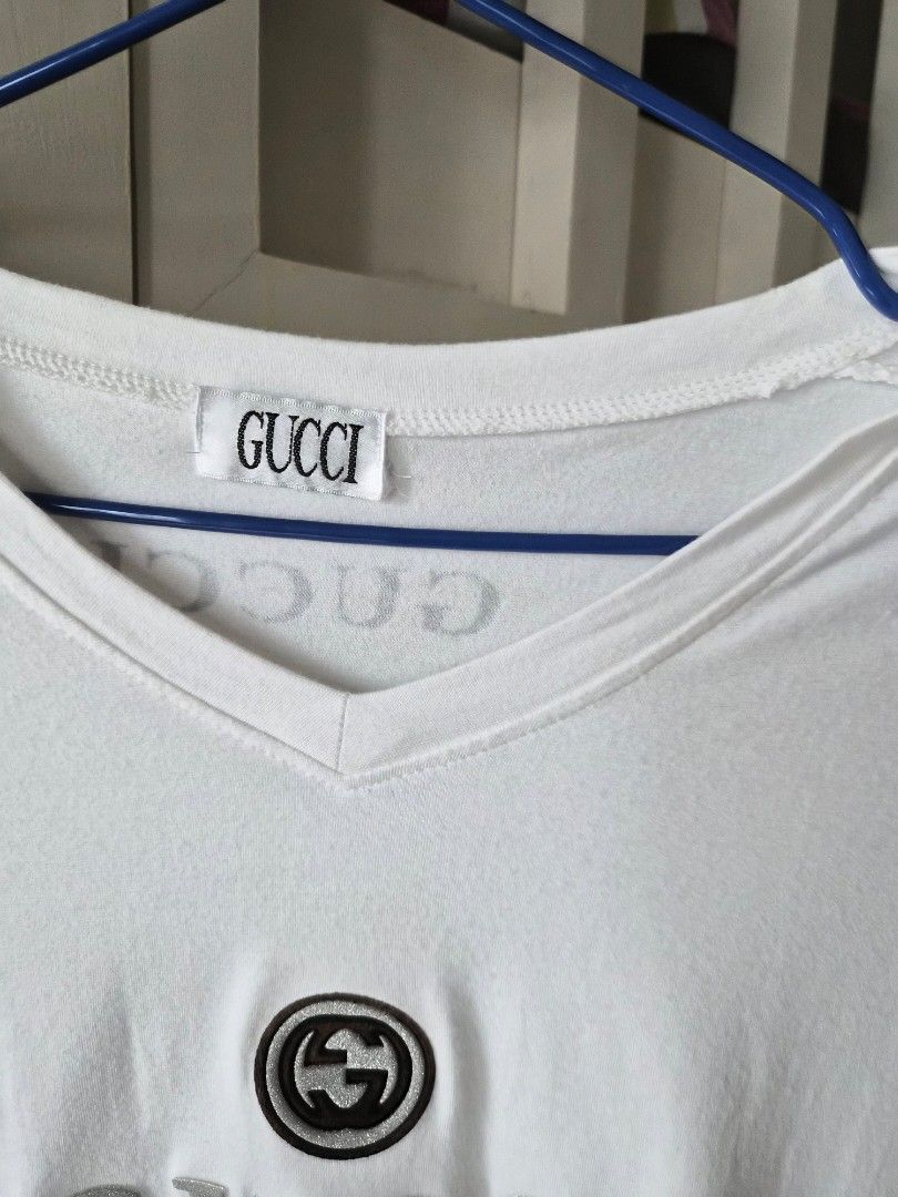 Gucci Long Sleeve V-Neck Shirt (Category: Luxury Apparel) located in Mandaluyong City. Submitted by haidwii (Listing ID 1407954659, Image 2). Description: - Gucci long-sleeved shirt - V-neck design - Features Gucci logo and emblem - Made in Italy - Black stripes on sleeves.