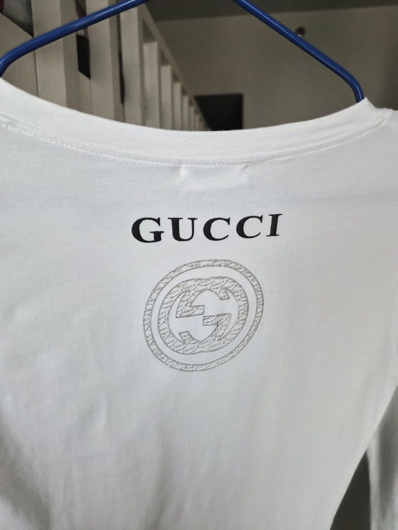 Gucci Long Sleeve V-Neck Shirt (Category: Luxury Apparel) located in Mandaluyong City. Submitted by haidwii (Listing ID 1407954659, Image 3). Description: - Gucci long-sleeved shirt - V-neck design - Features Gucci logo and emblem - Made in Italy - Black stripes on sleeves.