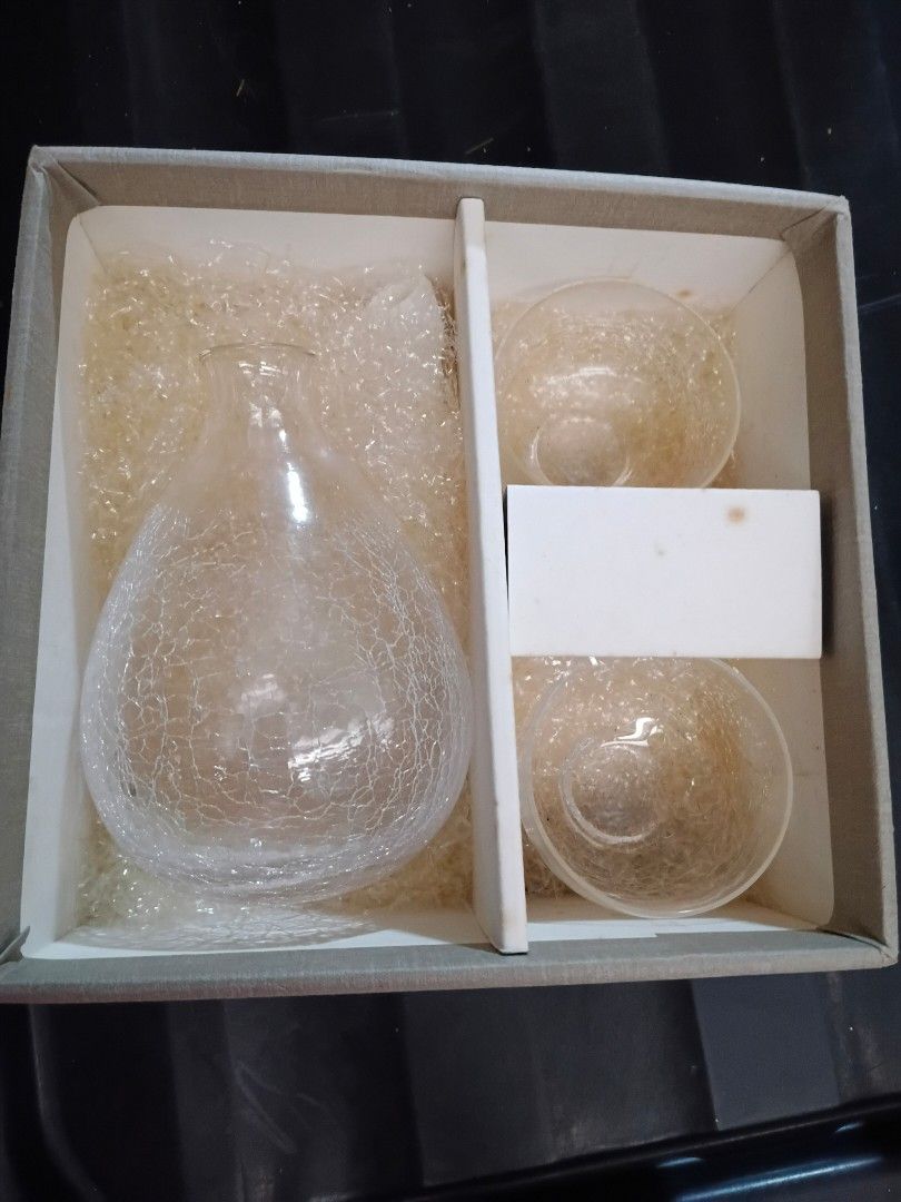 JC Glassware Set with Decanter and Glasses (Category: Other Kitchenware & Tableware) located in Quezon City. Submitted by plutus08 (Listing ID 1407953315, Image 1). Description: - Elegant glassware set includes a decanter and two matching glasses. - Features a sophisticated crackle design. - Ideal for serving beverages with style. - Box includes a JC logo. -bottle size 5" High -glass H almost 2" x W 2.5".